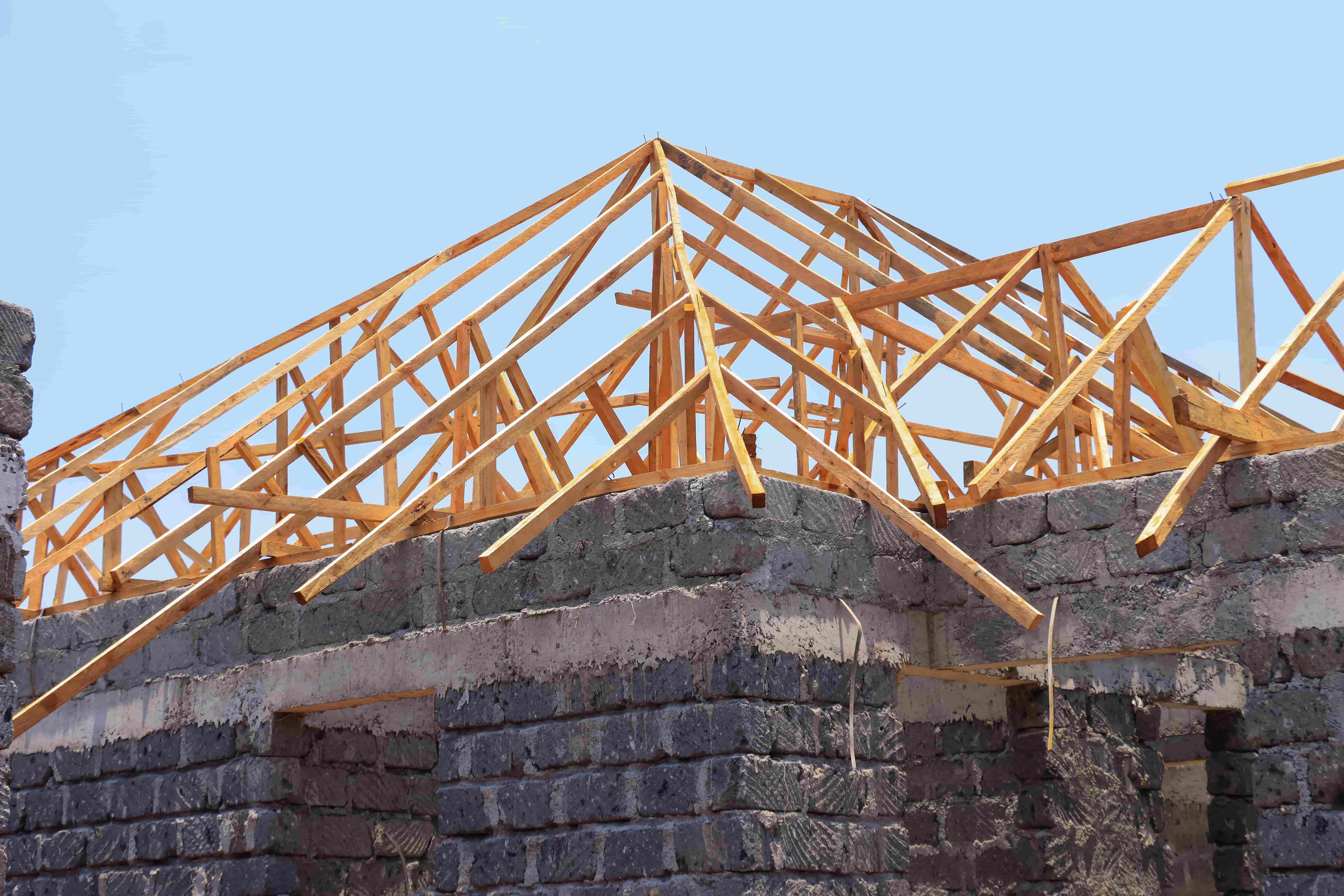 wooden-roof-trusses-on-stone-house-under-construction